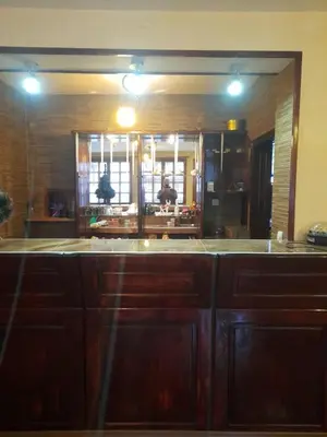 a kitchen with wooden cabinets and a large mirror at Къща за гости Дани in Govedartsi