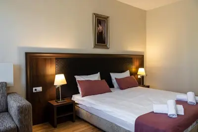 a bedroom with a large bed and a chair at Апартамент и Студия 