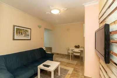 a living room with a couch and a tv and a table at Charming Artistic Central Apartment in Sofia