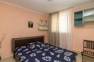 a bedroom with a bed with a blue comforter and a window at Charming Artistic Central Apartment in Sofia