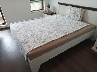 a bed in a bedroom with a white and brown comforter at One Bedroom Apartment 61 - Restaurant Stadium Plovdiv in Plovdiv
