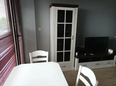 a dining room with a white table and chairs and a television at One Bedroom Apartment 61 - Restaurant Stadium Plovdiv in Plovdiv