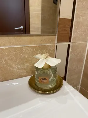a glass jar with a flower on top of a sink at M&R Apartment C13 - SPA Terra Complex in Razlog