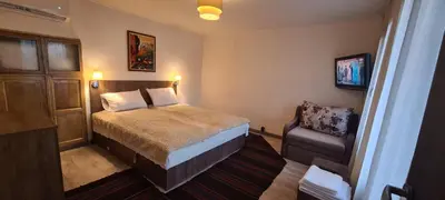 a small bedroom with a bed and a chair at стаи за гости Никол in Starosel