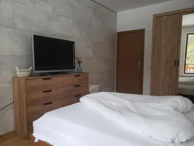 a bedroom with a bed and a television on a dresser at Cozy Rila Park Apartments in Borovets
