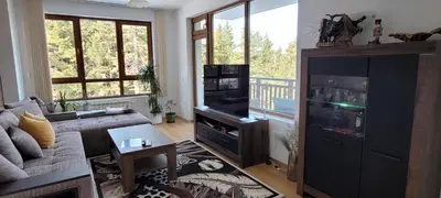 a living room with a couch and a tv at Cozy Rila Park Apartments in Borovets