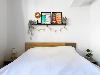 a bedroom with a white bed and a shelf on the wall at Budget Stay Near Sofias Lions Bridge in Sofia