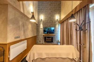 a bedroom with a bed and a tv on a wall at Pirin Golf Hotel&Spa Apartment 42 - private luxury apartment in Razlog
