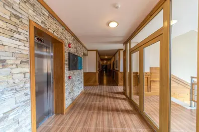 a hallway with a stone wall and sliding glass doors at Pirin Golf Hotel&Spa Apartment 42 - private luxury apartment in Razlog