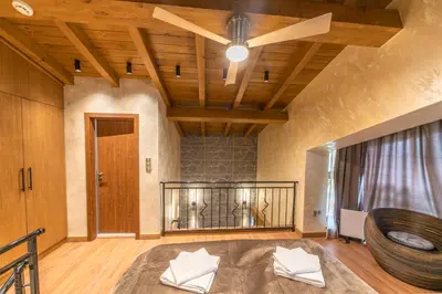 a room with a large bed with a wooden ceiling at Pirin Golf Hotel&Spa Apartment 42 - private luxury apartment in Razlog