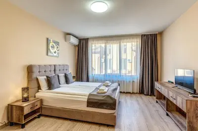 a bedroom with a large bed and a television at VALEMO Apart House in Devin