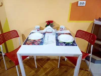 a white table with two red chairs and a white plate at 