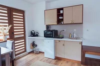 a kitchen with white cabinets and a sink and a microwave at Spacious stylish studio with large terrace and amazing view, 5 min to Gondola & Bar Str in Bansko