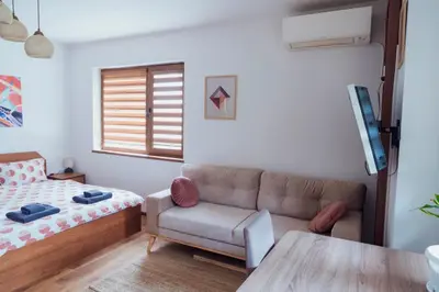 a living room with a couch and a bed at Spacious stylish studio with large terrace and amazing view, 5 min to Gondola & Bar Str in Bansko