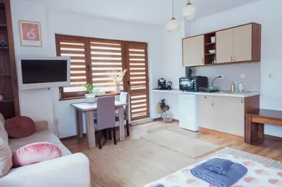 a living room with a table and a kitchen at Spacious stylish studio with large terrace and amazing view, 5 min to Gondola & Bar Str in Bansko