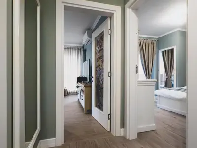 a bedroom with green walls and a hallway with a bed at Stylish 1BD - Free Private Garage in Plovdiv
