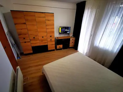 a bedroom with a bed and a desk and a window at Viva 3 Grand monastery in Pamporovo