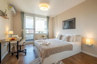 a bedroom with a bed and a desk and a window at City Oasis: Stylish Retreat in the Heart of Sofia in Sofia