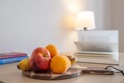 a pile of fruit on a wooden cutting board on a table at City Oasis: Stylish Retreat in the Heart of Sofia in Sofia