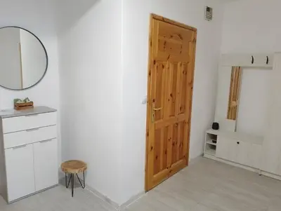 a room with a door and a stool and a mirror at Apartment Danilia in Sandanski