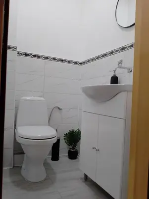 a white bathroom with a toilet and a sink at Apartment Danilia in Sandanski