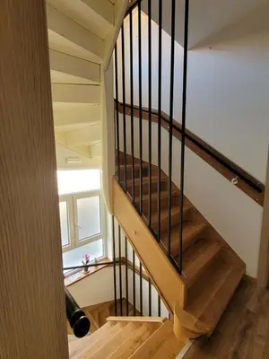 a wooden staircase with black railings in a house at The House - Central Boutique Apartments in Kyustendil