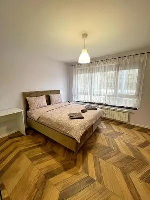 a bedroom with a bed and a large window at Azurro Residence in Sofia