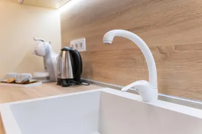a kitchen sink with two white faucets on a counter at Heart of the City 2-Bedroom Apartment in Plovdiv