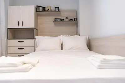 a white bed with white pillows in a bedroom at Heart of the City 2-Bedroom Apartment in Plovdiv