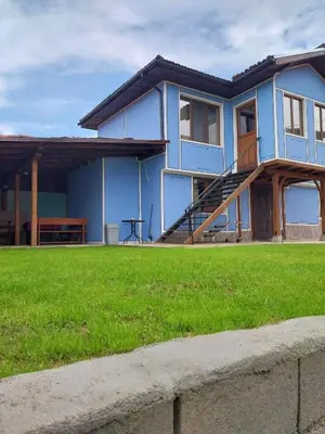 a blue house with a lawn in front of it at Kъща за гости Демария in Koprivshtitsa