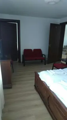 a bedroom with a bed and a couch and a tv at Kъща за гости Демария in Koprivshtitsa