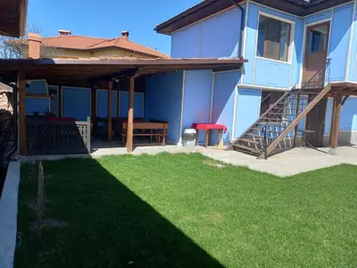 a house with a patio and a grass yard at Kъща за гости Демария in Koprivshtitsa