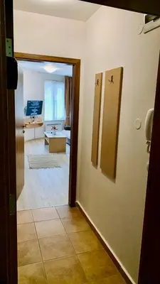 a room with a hallway with a living room at Апартамент Касъл in Pamporovo