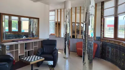 a lobby with a chair and a desk and windows at ТРАКАРТ-ПАРК in Plovdiv