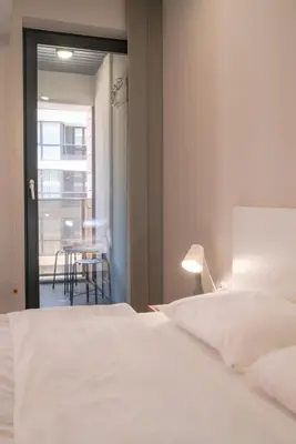 a bedroom with a white bed and a table at Bright Studio in the City Center in Sofia
