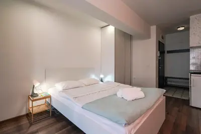 a bedroom with a large bed with two towels on it at Bright Studio in the City Center in Sofia