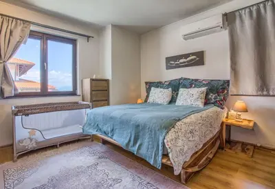a bedroom with a bed and a window at Pastels - 2BD in Trinity Bansko with underground parking by Flat Mаnager in Bansko