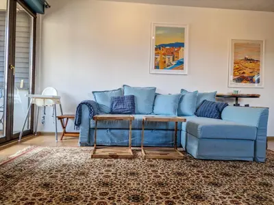 a blue couch sitting in a living room at Pastels - 2BD in Trinity Bansko with underground parking by Flat Mаnager in Bansko