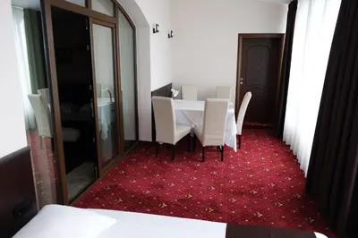 a dining room with a table and chairs on a red carpet at Hotel Dragalevtsi in Sofia