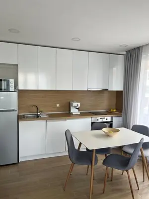 a kitchen with white cabinets and a table and chairs at Bunaya Sofia in Sofia