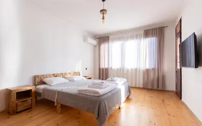 a bedroom with a bed and a large window at Къща за гости Константин и Елена - гр. Девин in Devin