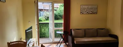 a living room with a couch and a sliding glass door at Bojurland, Bansko, Bulgaria in Bansko