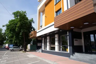 a building on the side of a street with a car at Hotel Forum City in Pazardzhik