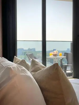a bed with white pillows in front of a window at Private Apartment for 4 Guests and Parking in Plovdiv