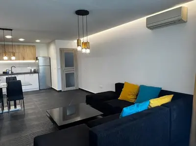 a living room with a blue couch and a kitchen at Blue & Gold Stylish Apartment in Sofia