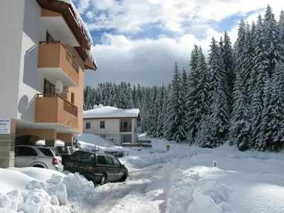 a parking lot covered in snow next to a building at Krasi Apartments in Zornitsa Complex in Stoykite