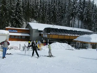 a group of people on skis in the snow near a building at Krasi Apartments in Zornitsa Complex in Stoykite