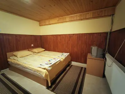 a small bedroom with a bed and a tv at Комплекс Петлето in Smolyan
