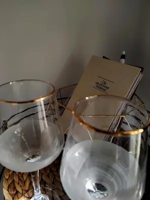 two wine glasses sitting on a table with a box at Gold Infinity in Velingrad