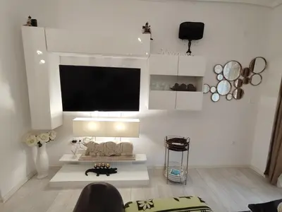 a white living room with a tv on the wall at Gold Infinity in Velingrad